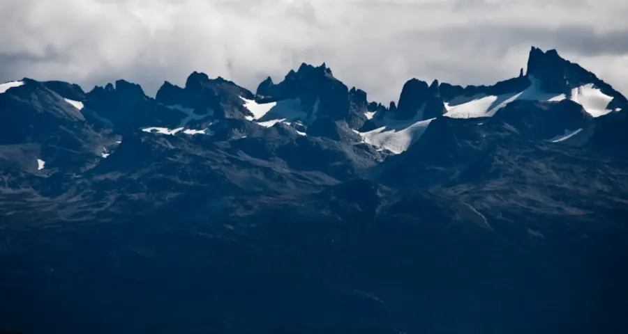 Jagged snow-dusted peaks under heavy clouds