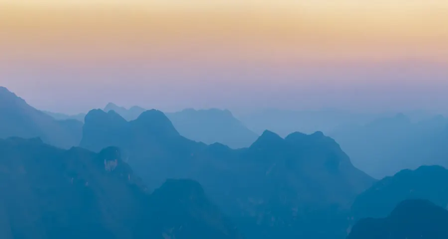 Layers of misty mountain ridges at dusk