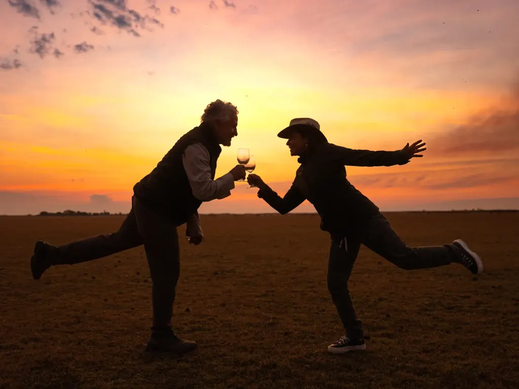 Two travelers striking playful poses at sundown
