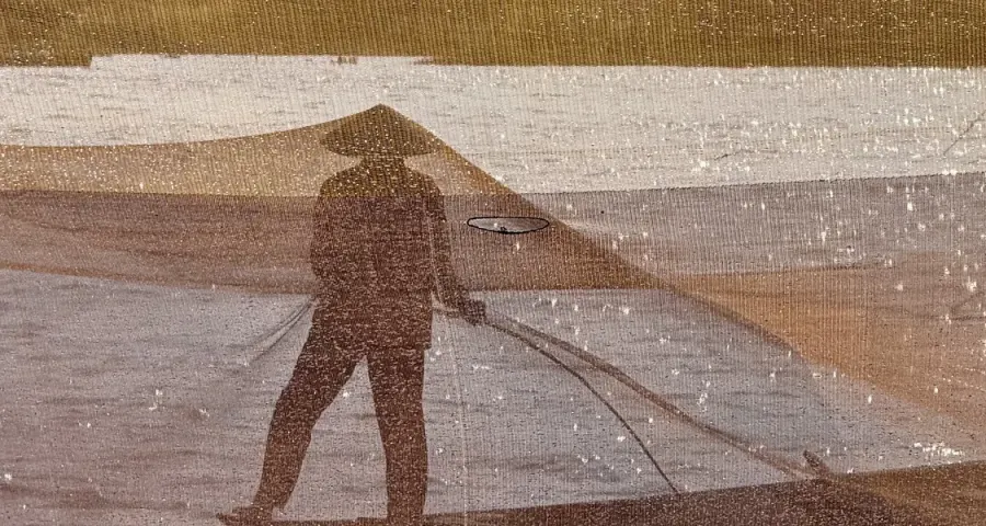 Fisherman casting a traditional net at golden hour