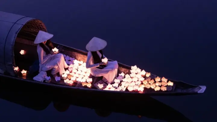 Boat filled with flower lanterns on the river at dusk